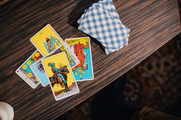 Cartes de tarot étalées côte à côte sur une table en bois