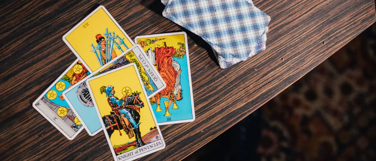 Cartes de tarot étalées côte à côte sur une table en bois