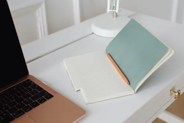 Carnet ouvert et stylo posés sur un bureau clair, pour formuler sa question