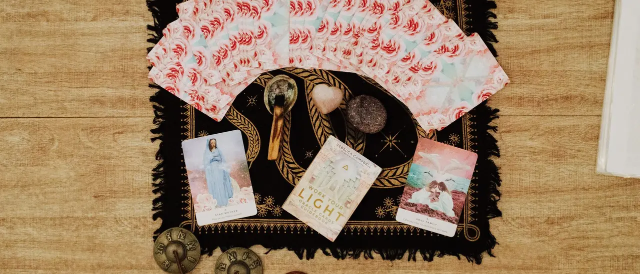 Cartes oracle à dos de roses, quartz rose en forme de cœur et cristaux sur un tissu étoilé