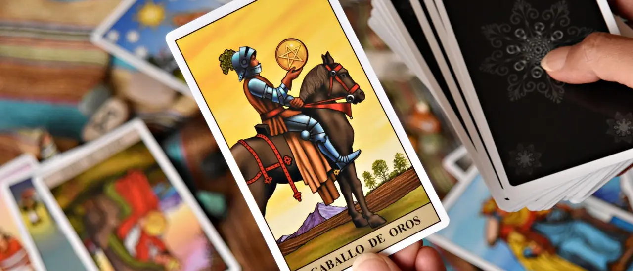 Cartes de tarot et pièces disposées sur un bureau, lumière chaude