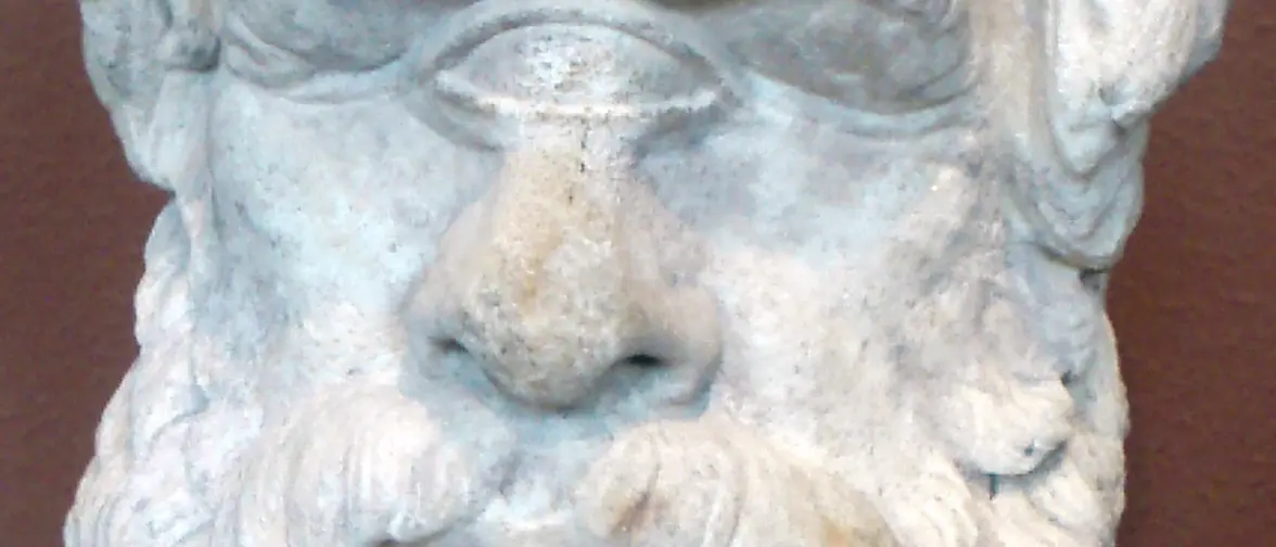 Sculpture antique représentant la tête d'un cyclope à l'œil unique au milieu du front