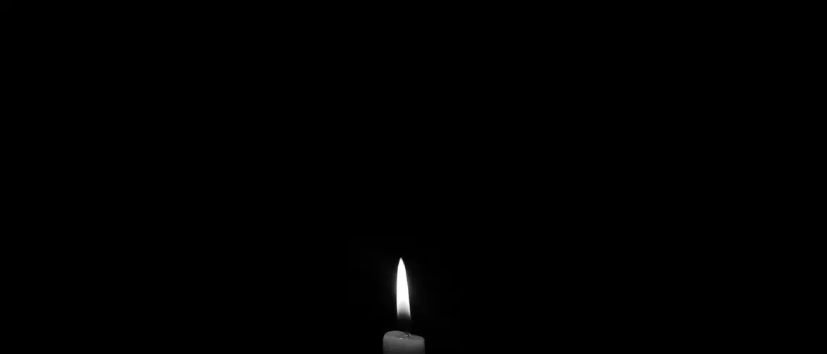 Une bougie noire allumee dans la penombre
